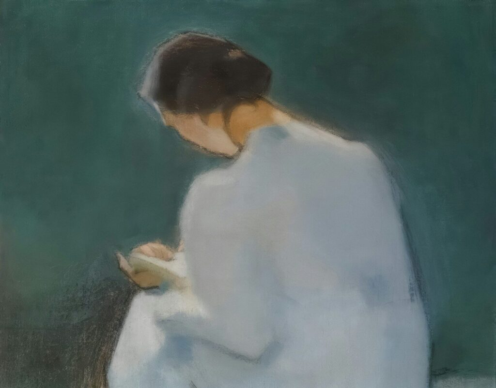 A woman in a white dress reads a book.